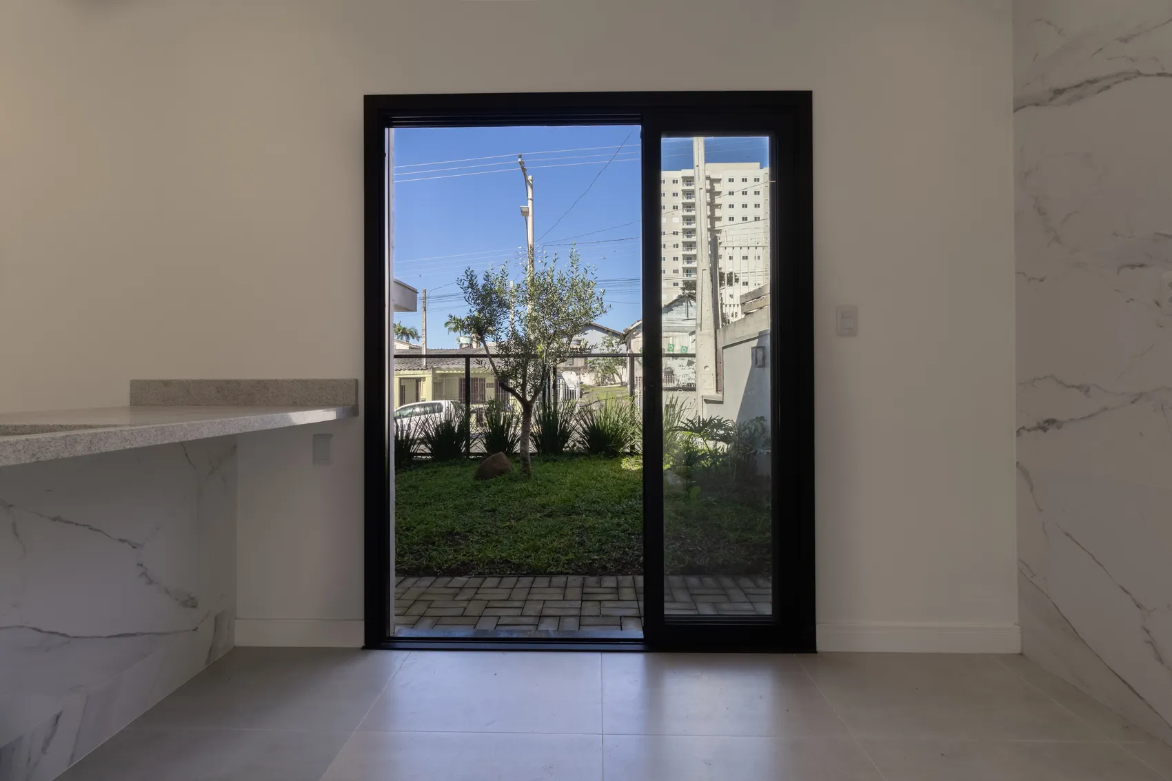 Bancada de mármore com porta de vidro para o jardim