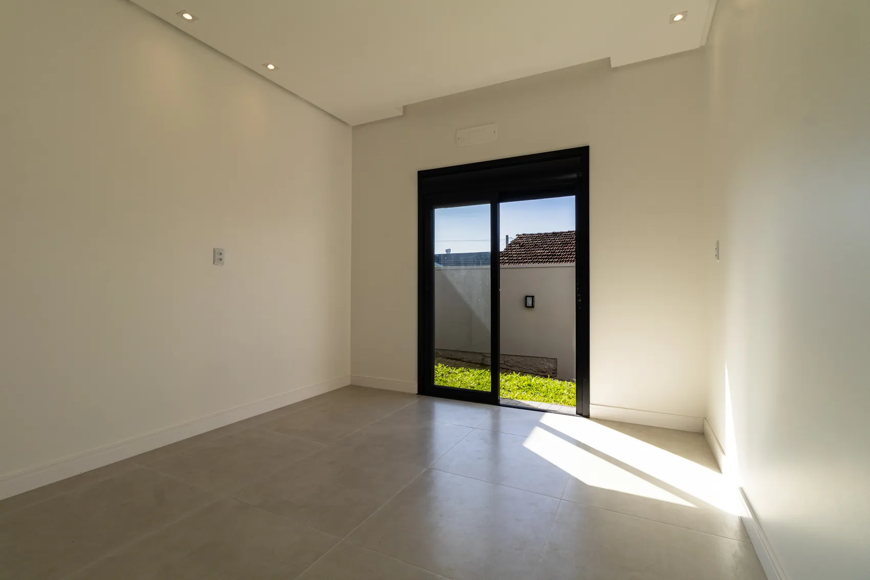 Sala com luz do sol entrando pela porta de vidro
