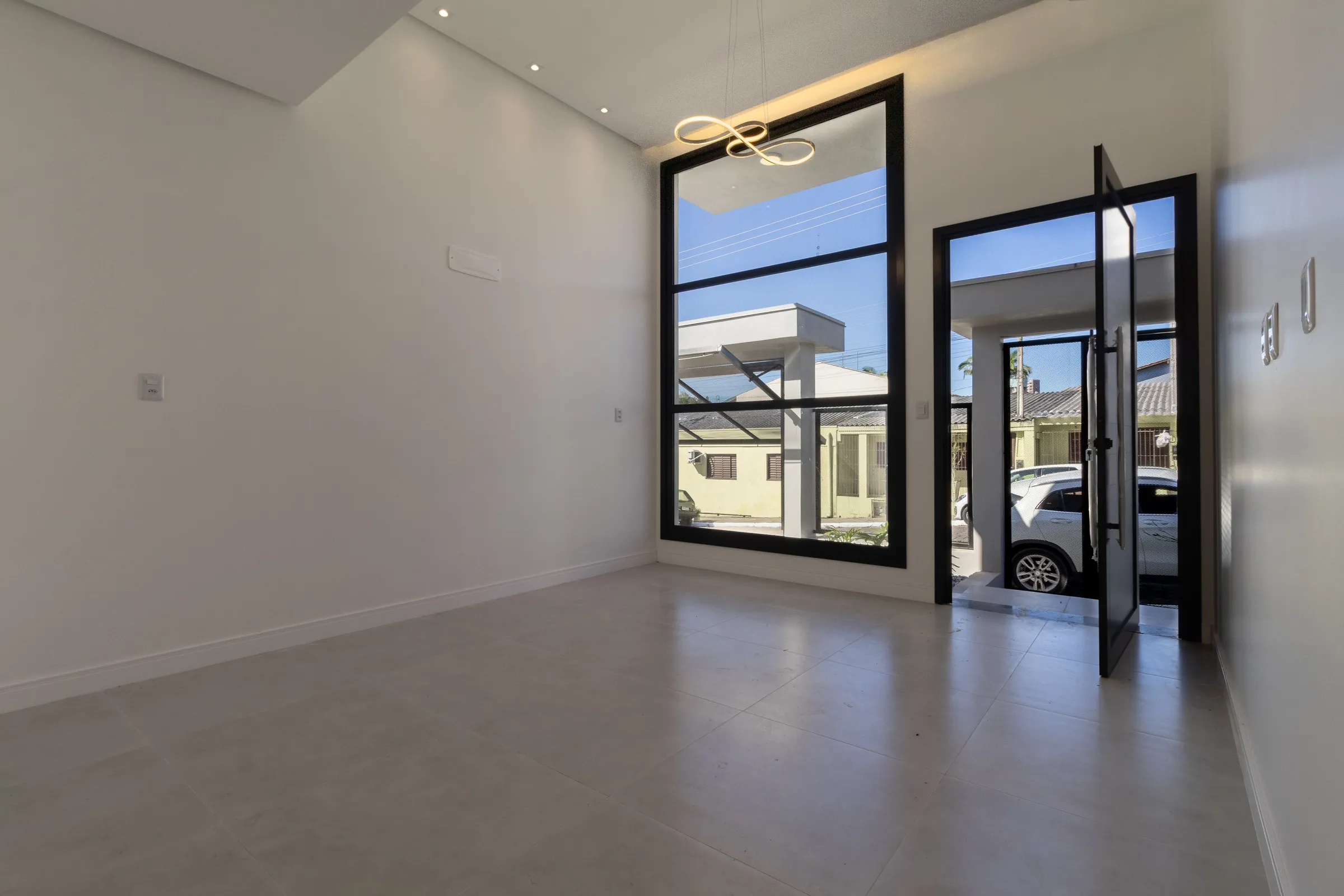 Living iluminado com porta de vidro para a frente da casa